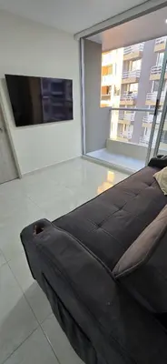 a black couch in a room with a large window at Apartamento Plazuela Portal Del Prado in Barranquilla