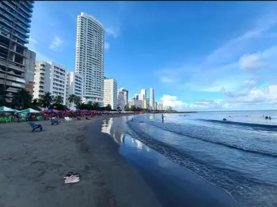 a beach with people and buildings and the ocean at Hermoso apartamento caribeño Bocagrande Cartagena 100 metros in Cartagena de Indias