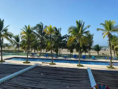 a swimming pool with palm trees and a beach at Apartamento con excelente Vista al Mar in Cartagena de Indias