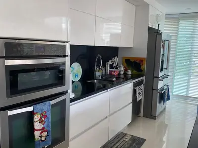 a kitchen with white cabinets and a black refrigerator at Apartamento con excelente Vista al Mar in Cartagena de Indias