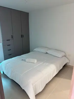 a bedroom with a large white bed with two pillows at Apartamento moderno en norte de la ciudad in Barranquilla