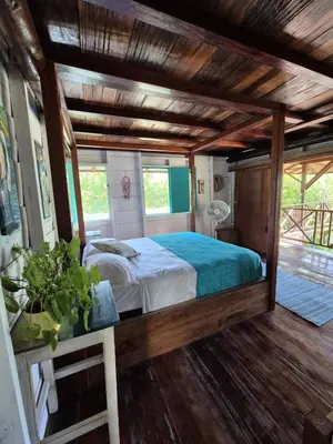 a bedroom with a bed in a room with wooden floors at Veleta Playa Calao in San Antero