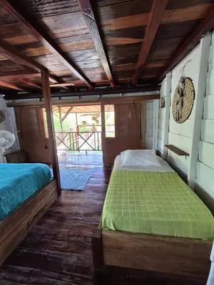a bedroom with a bed with a green comforter at Veleta Playa Calao in San Antero