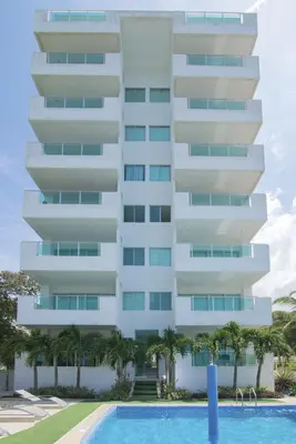 a tall white building with a swimming pool in front of it at Magico Apartamento Frente al Mar 3 Habitaciones B41 in Coveñas