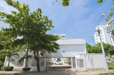 a white building with a tree in front of it at Magico Apartamento Frente al Mar 3 Habitaciones B41 in Coveñas