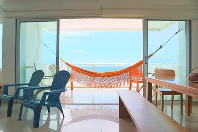 a living room with a hammock and a table and chairs at Magico Apartamento Frente al Mar 3 Habitaciones B41 in Coveñas