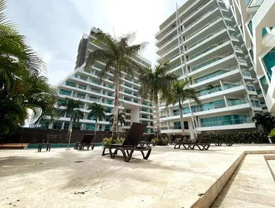 a large building with palm trees in front of it at Sonesta Apartamento en Cartagena in Cartagena de Indias