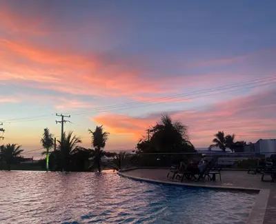 a group of people sitting around a pool at sunset at Sonesta Apartamento en Cartagena in Cartagena de Indias