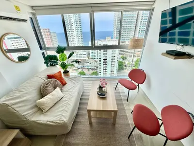 a living room with a couch and red chairs at magnoloft1104 in Cartagena de Indias