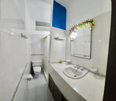 a bathroom with a sink and a toilet and a mirror at Apartamento playa Bocagrande Los Delfines Cartagena in Cartagena de Indias