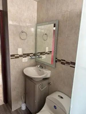 a bathroom with a toilet and a sink and a mirror at Apartamento 84 - 2 habitaciones in Barranquilla