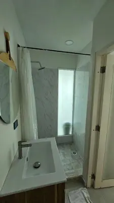 a white bathroom with a shower and a sink at Loft MR1-4G facing the sea in a high level neighborhood in Cartagena de Indias