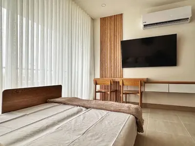 a bedroom with a bed and a flat screen tv at Spectacular Beachfront Apartment in Cartagena de Indias