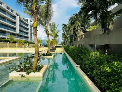 a swimming pool with palm trees and a building at Spectacular Beachfront Apartment in Cartagena de Indias