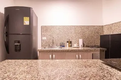 a kitchen with a black refrigerator and a sink at Serene Bay by Wynwood House in Cartagena de Indias