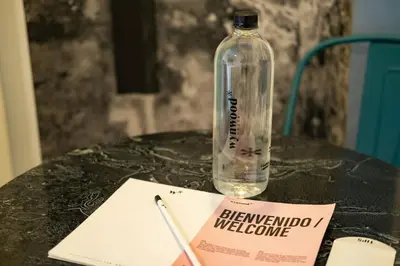 a bottle of water sitting on a table with a sign at Serene Bay by Wynwood House in Cartagena de Indias