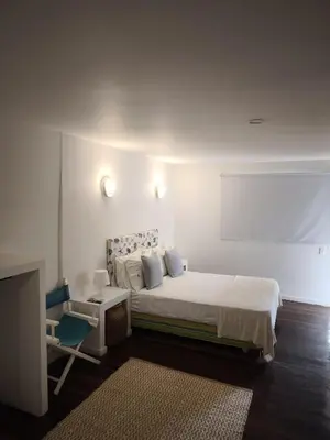 a white bedroom with a bed and a tv at Playa Banana Manzanillo del Mar in Cartagena de Indias