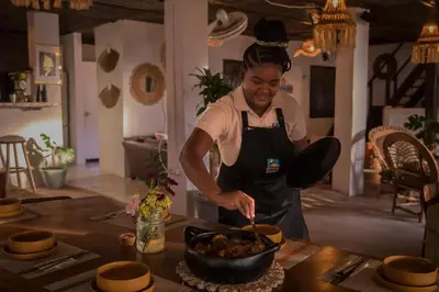a woman in a kitchen preparing food in a bowl at Playa Banana Manzanillo del Mar in Cartagena de Indias