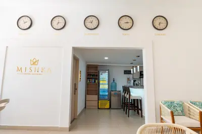 a room with clocks on the wall and a dining room at Mishka Hotel Boutique Habitación 103 in Cartagena de Indias