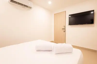a white bedroom with two towels on a bed at Mishka Hotel Boutique Habitación 103 in Cartagena de Indias