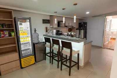 a kitchen with a bar with stools and a refrigerator at Mishka Hotel Boutique Habitación 103 in Cartagena de Indias