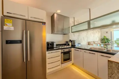 a kitchen with white cabinets and a stainless steel refrigerator at The best Luxury Suite in Cartagena in Cartagena de Indias