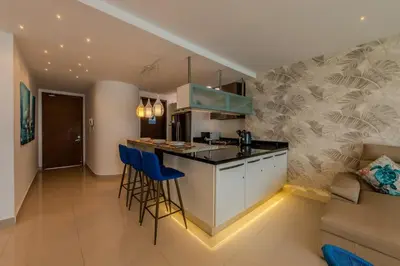 a kitchen with a bar with stools and a couch at The best Luxury Suite in Cartagena in Cartagena de Indias