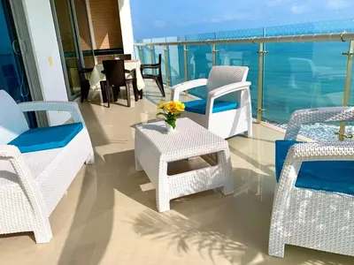 a balcony with chairs and a table with a view of the ocean at The best Luxury Suite in Cartagena in Cartagena de Indias