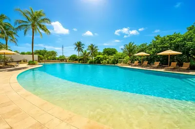 a swimming pool with palm trees and umbrellas at Apartamento de Ensueño!! Sonesta Cartagena Salida Playa Vistas WOW Morros in Cartagena de Indias
