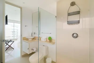 a white bathroom with a toilet and a sink at Apartamento de Ensueño!! Sonesta Cartagena Salida Playa Vistas WOW Morros in Cartagena de Indias