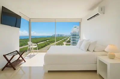 a bedroom with a white bed and a large window at Apartamento de Ensueño!! Sonesta Cartagena Salida Playa Vistas WOW Morros in Cartagena de Indias