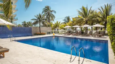 a pool at a resort with chairs and umbrellas at Morros Ultra, Beachfront & 2 Bedrooms by Inmobiliaria MFR in Cartagena de Indias