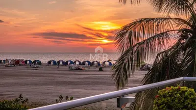 a sunset on the beach with a pier and the ocean at Morros Ultra, Beachfront & 2 Bedrooms by Inmobiliaria MFR in Cartagena de Indias