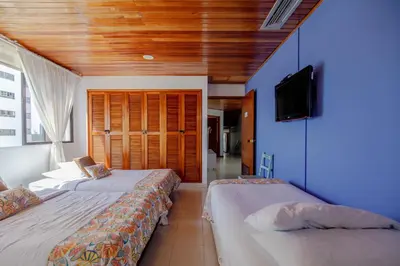 a bedroom with two beds and a flat screen tv at Spacious apartment in Bocagrande near the sea in Cartagena de Indias