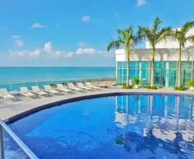 a swimming pool with chairs and the ocean in the background at Tu lugar favorito en Cartagena in Cartagena de Indias