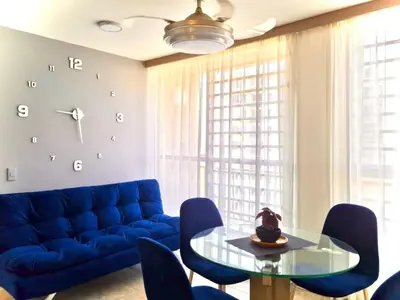 a living room with a blue couch and a glass table at Apartamento con Vistas a la Ciudad in Barranquilla