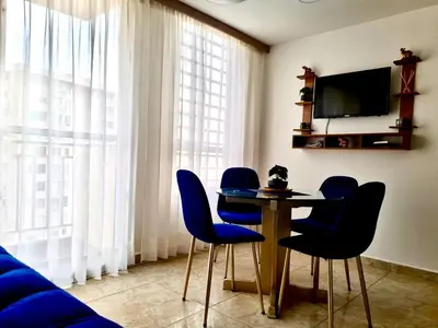 a room with a table and chairs and a tv at Apartamento con Vistas a la Ciudad in Barranquilla