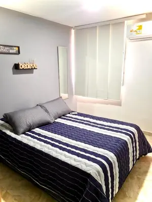 a bedroom with a bed with a striped blanket on it at Apartamento con Vistas a la Ciudad in Barranquilla