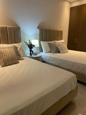 a bedroom with two beds and a table with a lamp at Mistral Exclusive oceanfront apartment with balcony in Cartagena de Indias