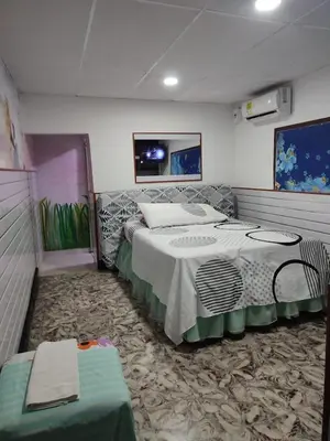 a room with two beds and a table in it at Hostal Marhú in Cartagena de Indias