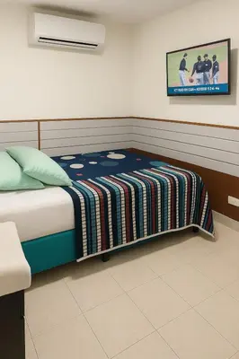 a bedroom with a bed with a blanket on it at Hostal Marhú in Cartagena de Indias