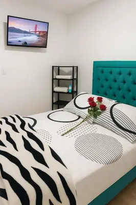 a zebra print bed with a vase of flowers on it at Hostal Marhú in Cartagena de Indias