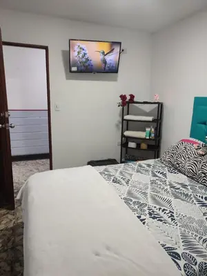a bedroom with a bed and a tv on the wall at Hostal Marhú in Cartagena de Indias