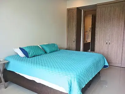 a bedroom with a bed with blue sheets and a cabinet at Apartamento en condominio de lujo morros eco. in Cartagena de Indias