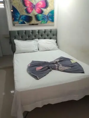 a robe laying on top of a bed at Hostal Costacaribeam in Barranquilla