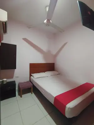 a bedroom with a bed and a ceiling fan at Hotel Madeleine Inn Sede Sur in Barranquilla