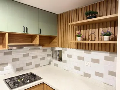 a kitchen with wooden cabinets and a stove top oven at APTO LODGE - Confortable y acogedor apartamento al norte de Barranquilla vía a Puerto Colombia in Barranquilla