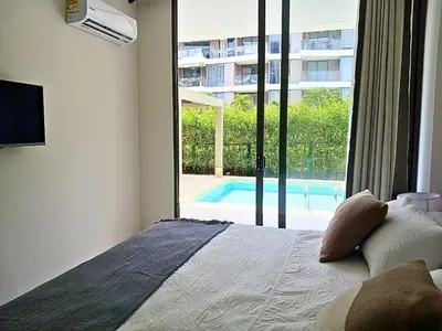 a bedroom with a bed with a view of a pool at Lujoso Apto con Piscina Privada y salida a playa in Cartagena de Indias
