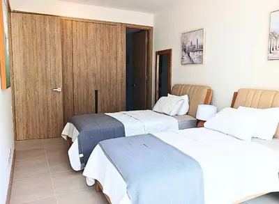 a hotel room with two beds and a closet at Lujoso Apto con Piscina Privada y salida a playa in Cartagena de Indias