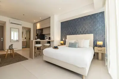 a bedroom with a large white bed and a kitchen at Suite romántica con terraza lounge y vista panorámica CB834 in Cartagena de Indias